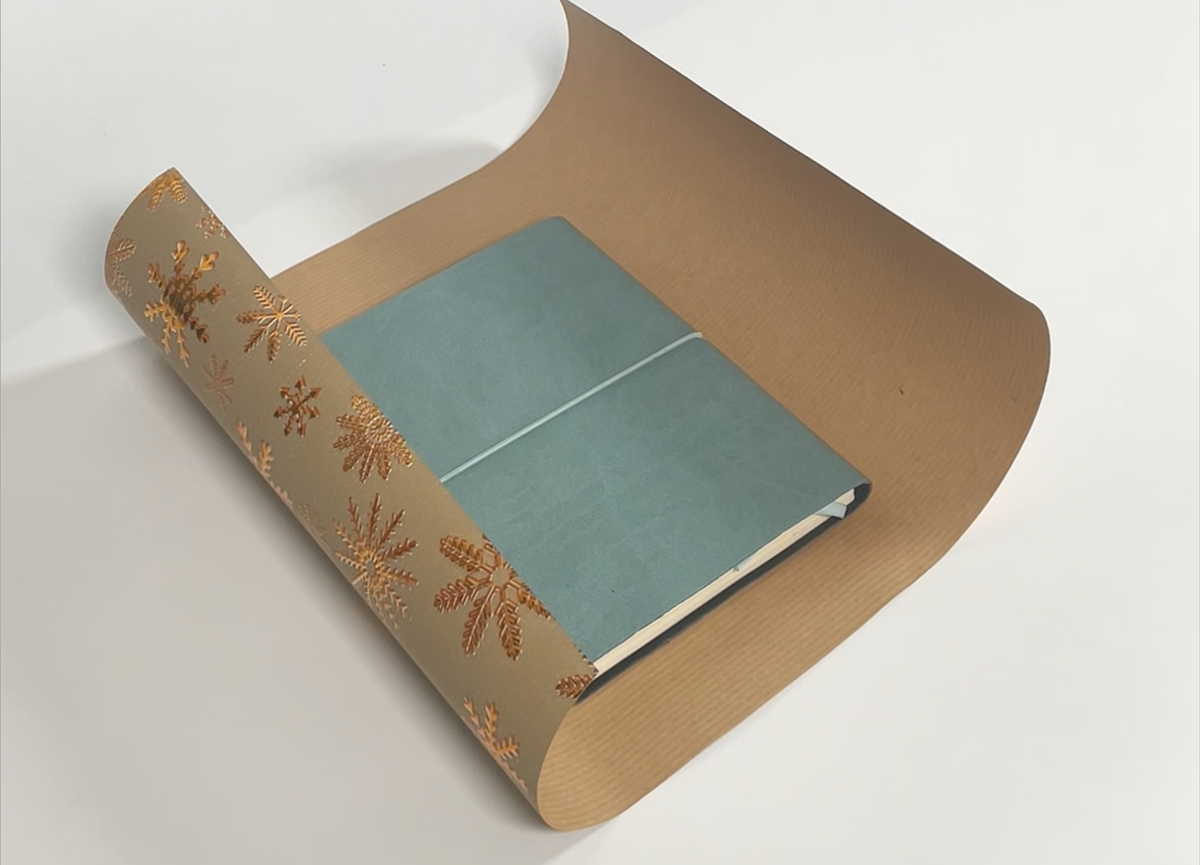 Livre emballé dans du papier cadeau festif avec un design floral