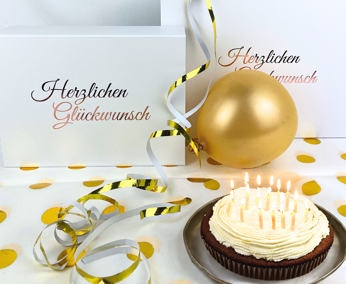 Boîtes d'anniversaire blanches avec un gâteau en bougie et des décorations dorées